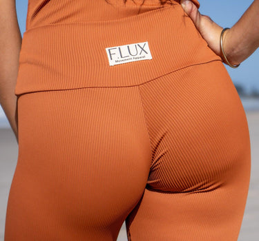 Stylish and sustainable terracotta-colored biker shorts with premium ribbed texture, offering a flattering fit and opaque coverage for all types of workouts, by F.lux.