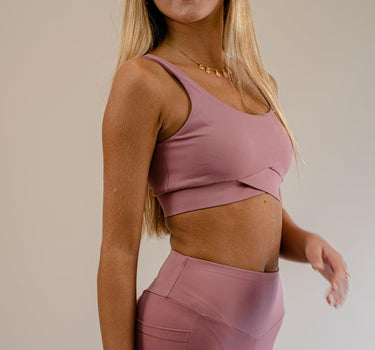 Barbie pink Bruna Sports Bra showcasing V-back and crossover front design, blending style with sustainability in activewear.